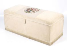 An upholstered ottoman with padded lid and later applied needlework tapestry.