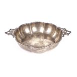 A silver ribbed, twin handled porringer.