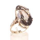A vintage oval smoky quartz single stone ring. The oval mixed-cut smoky quartz approx. 23.