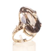 A vintage oval smoky quartz single stone ring. The oval mixed-cut smoky quartz approx. 23.