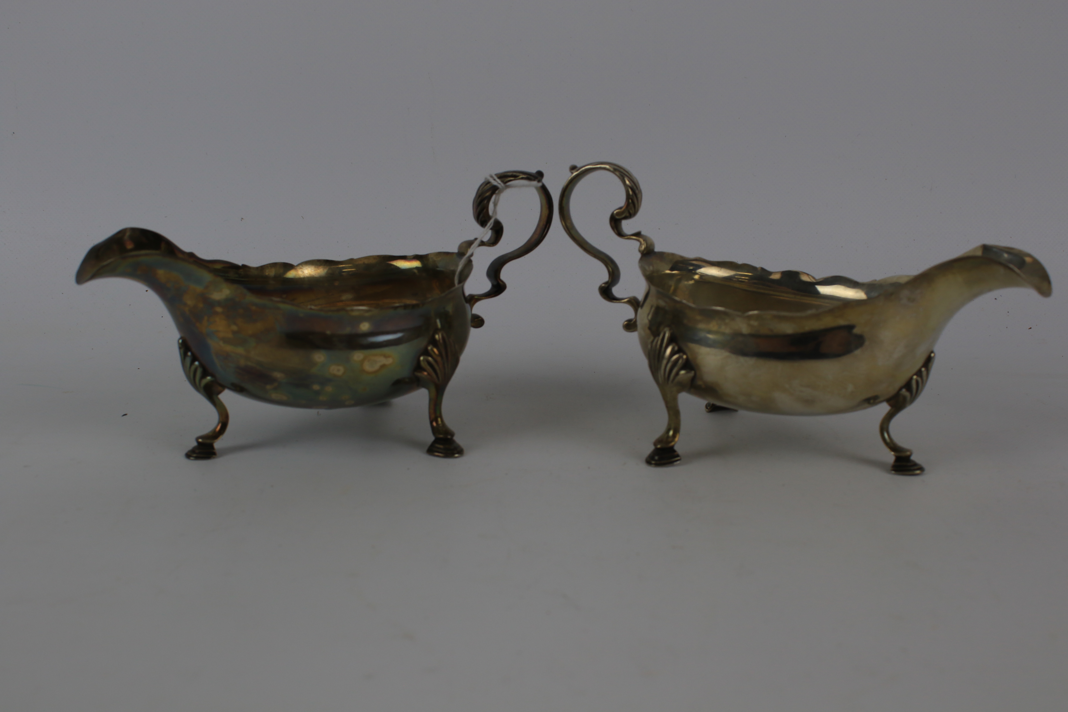 A pair of silver sauce boats with foliate decorated handles. Raised on shell and hoof supports. - Image 4 of 6