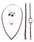 A suite of white metal and garnet set jewellery and a dress watch.