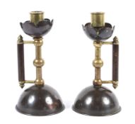 A pair of late 19th century copper and brass candlesticks in the style of Christopher Dresser.