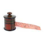 A Stuart Tartan ware cylinder tape measure. The pink printed tape wound from a rosewood finial, H3.