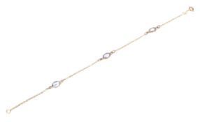 A modern 9ct gold and blue spinel three stone bracelet.