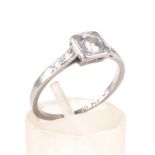 An Art Deco diamond solitaire ring with tiny diamond shoulders.