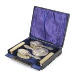 A cased six piece silver backed dressing table set.