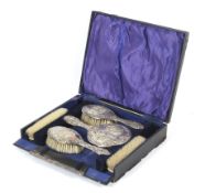 A cased six piece silver backed dressing table set.