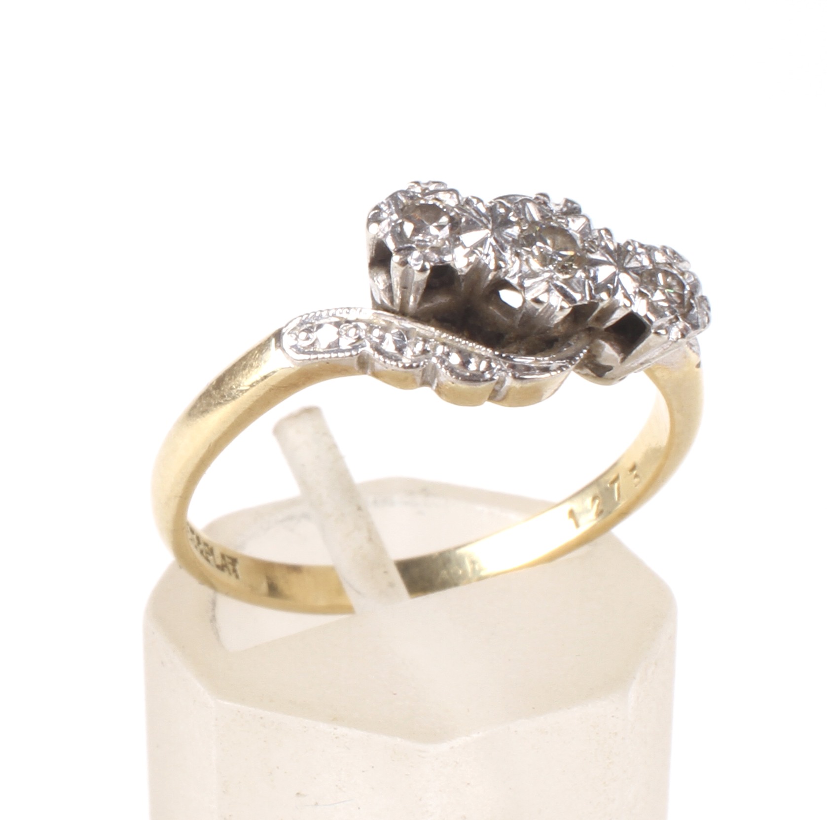 A mid 20th century gold and diamond three stone cross-over ring.