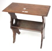 A mahogany occasional table. With lower magazine rack between pierced supports.