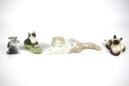 Four ceramic figures of cats.