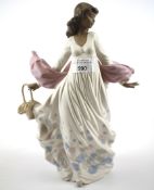 A large Lladro figure depicting a lady in a flowing dress, holding a basket.