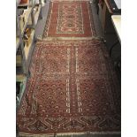 Two 19th century Eastern floor rugs. One with central medallions on a red ground (92cm x 185cm).