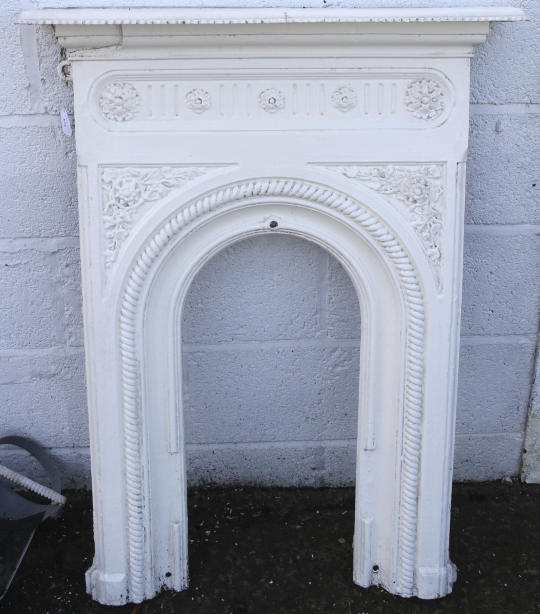 A white painted cast iron Victorian bedroom fire place surround.