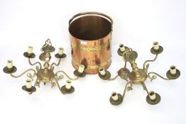 A pair of six sconce brass chandeliers and a brass log basket.
