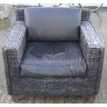 A contemporary wicker armchair with cushions.