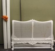 A 20th century white painted French bed with rattan head board.