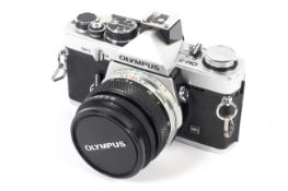 An Olympus OM-2 35mm SLR camer. With a 50mm 1:1.