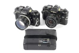 Two Minolta X-700 35mm SLR cameras. With a 58mm 1:1.4 MC Rokkor-PF lens and a 24mm 1:2.