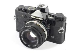 An Olympus OM-1N 35mm SLR camera. Black, with a 50mm 1:1.