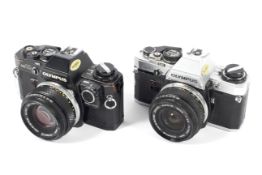 Two Olympus OM10 35mm SLR cameras. One black with a 50mm 1:1.