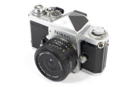 A silver Nikon F 35mm SLR eye level camera. With a 35mm 1:2.