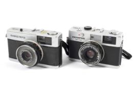 Two Olympus 35mm cameras.