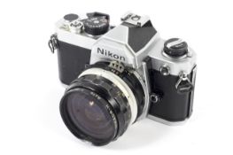 A silver Nikon FE 35mm SLR camera. With a 28mm 1:3.