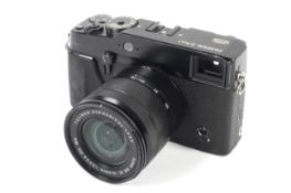 A Fujifilm X-Pro 1 mirrorless digital camera. With a 16-50mm 1:3.5-5.6 Fujinon Aspherical lens.