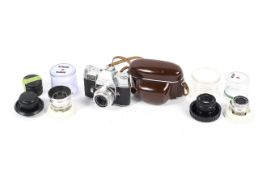 A Kodak Retina reflex III camera with an assortment of lenses.