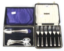 Two sets of silver flatware.