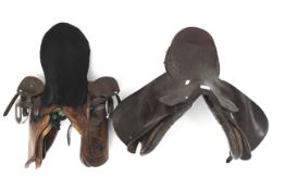 Two brown leather horse saddles.