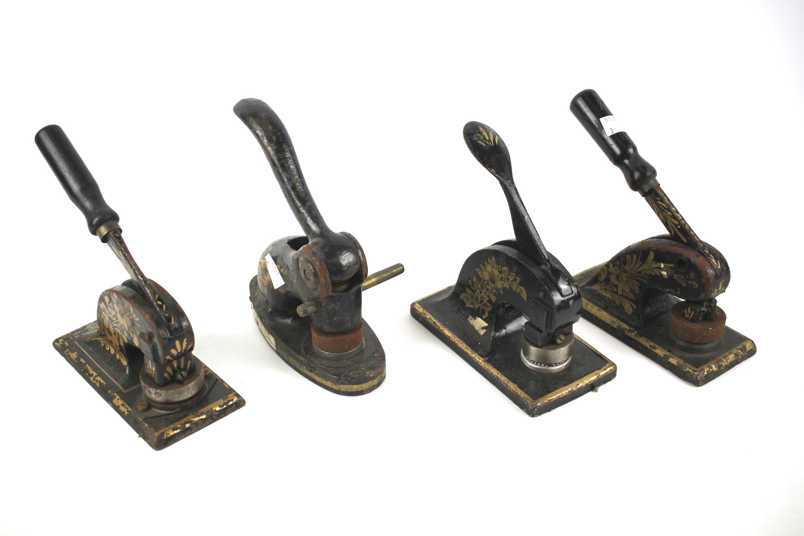 Four Victorian seal press 'shoes' decorated in gilt on a black ground.
