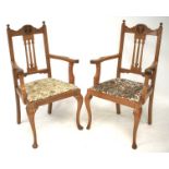 A pair of oak elbow chairs of ecclesiastical design.
