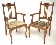 A pair of oak elbow chairs of ecclesiastical design.