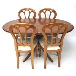 A contemporary wooden extendable dining table and four chairs.