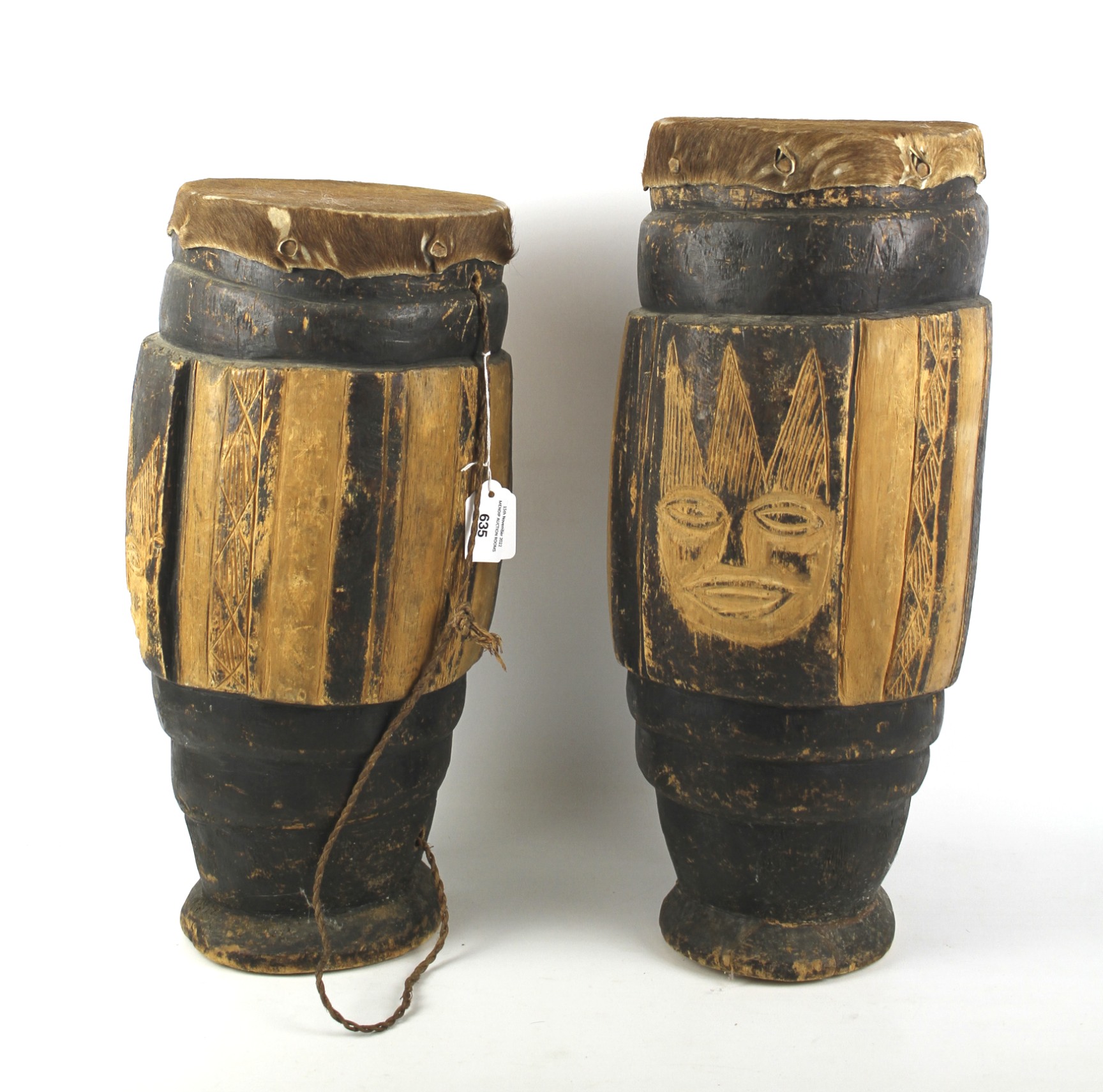 Two large vintage wooden and hide-covered African tribal drums.