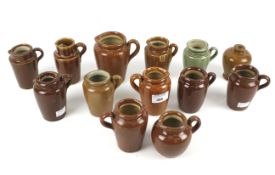 Various brown salt-glazed stoneware jugs in sizes, a small vase and a green-glazed jug similar.