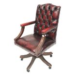 A faux leather button back and stud work captains swivel chair.