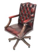 A faux leather button back and stud work captains swivel chair.