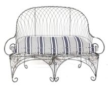 A metal wirework two-seater garden bench.