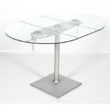 An oval glass drop leaf dining table. Raised on a turned metal column, on a square base, L124.