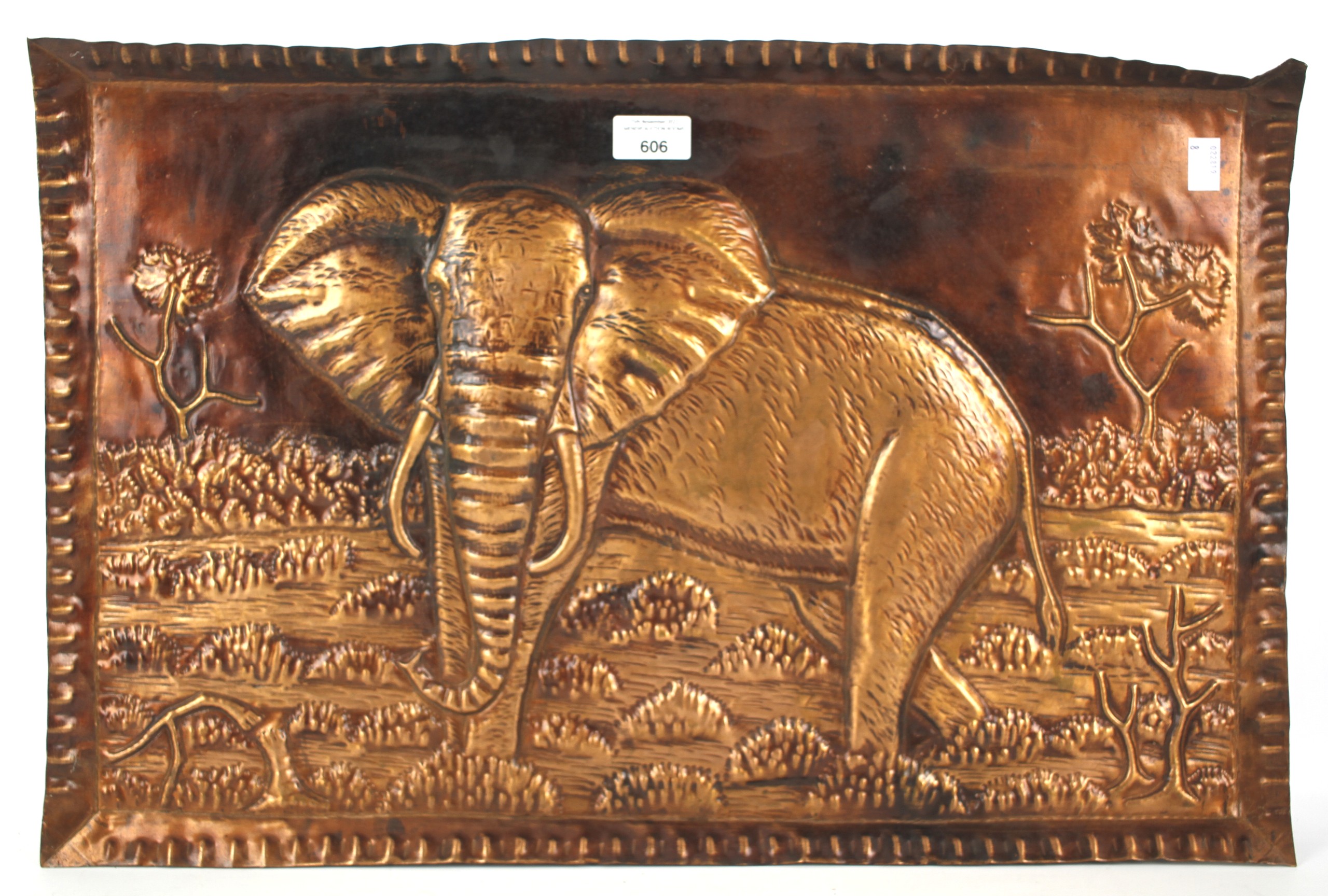 A rectangular copper tray depicting an elephant in landscape in high relief.