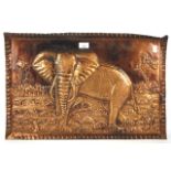 A rectangular copper tray depicting an elephant in landscape in high relief.