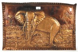 A rectangular copper tray depicting an elephant in landscape in high relief.