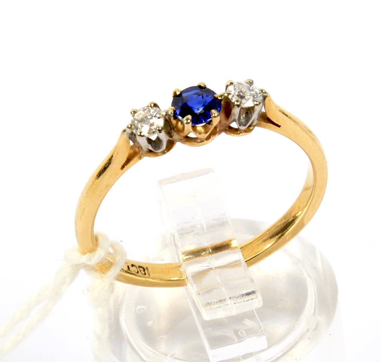 A yellow metal sapphire and diamond three stone ring.