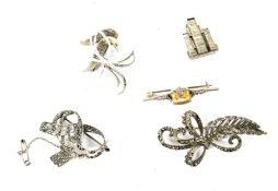 A collection of five Art Deco white metal brooches.