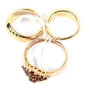 Three yellow metal ladies' rings. Including garnet and onyx. Weight 11.9g.