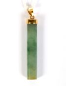 A comtemporary yellow metal and jade pendant. The jade of cylindrical form, L4.