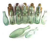 An early 20th century codd neck glass bottle and stoneware ginger beer bottles.